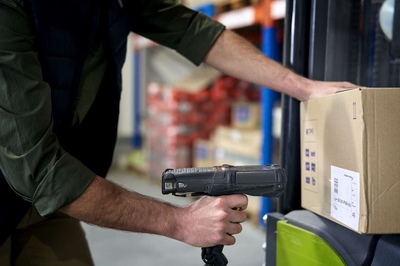 Warehouse worker scanning parcels for logistics data capture